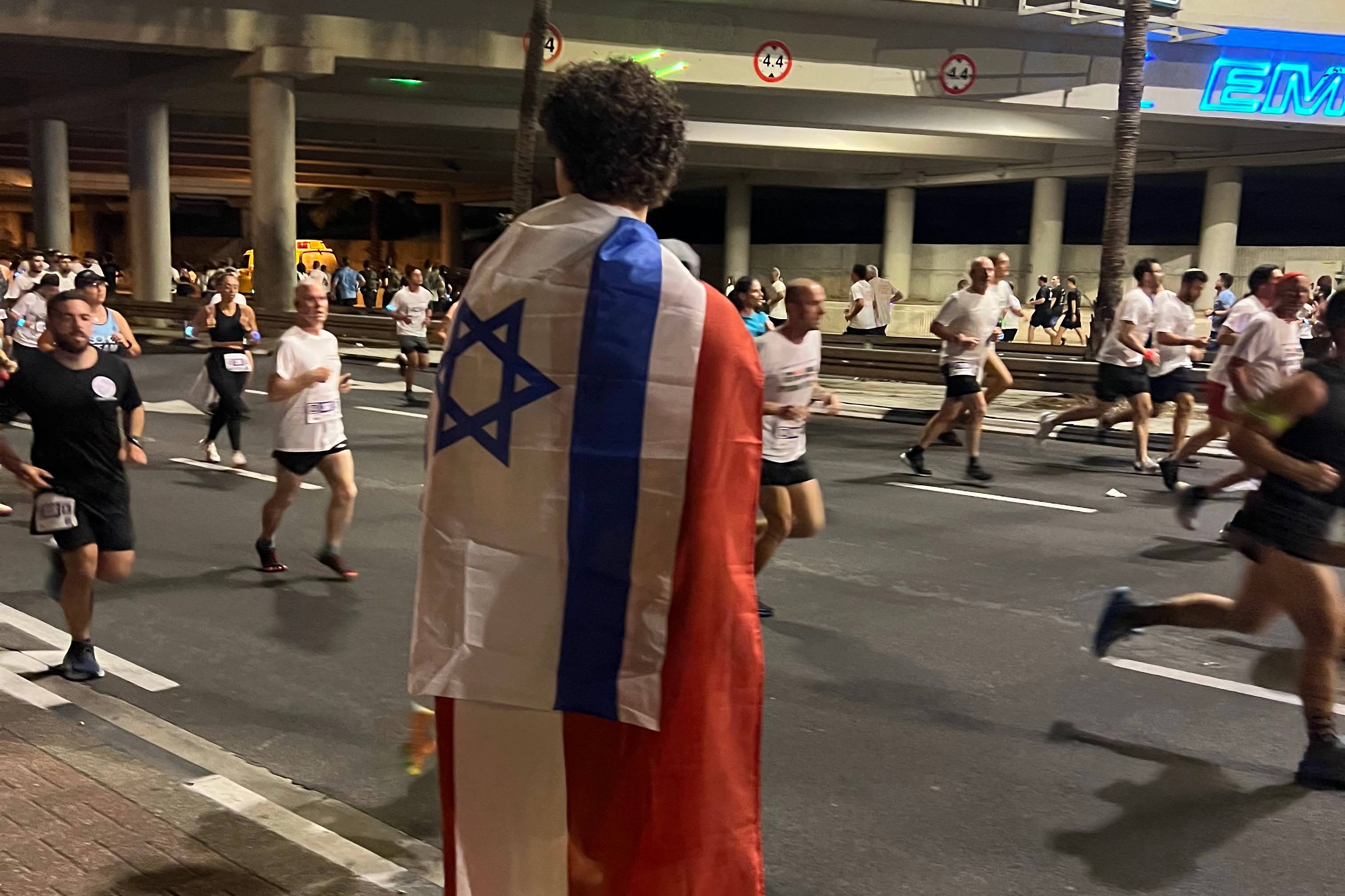 Running with both Israeli and Latvian flags